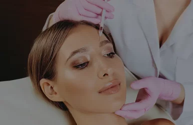 A woman gets a forehead botulinum injection from a professional in a clinical or spa setting.