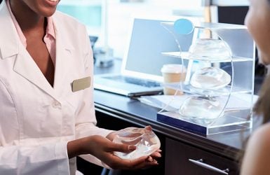 Doctor explains breast implant to patient in medical office