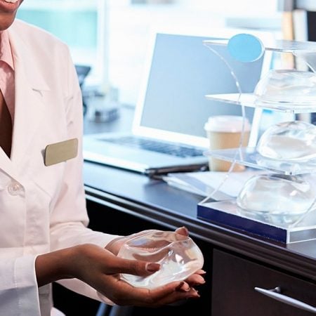 Doctor explains breast implant to patient in medical office