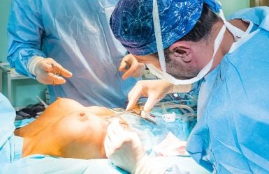 Surgeons perform breast reduction on a patient