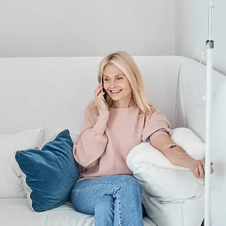 Blonde woman in pink sweater on sofa