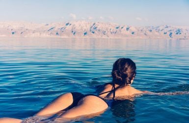 Person in black swimsuit floats on calm water
