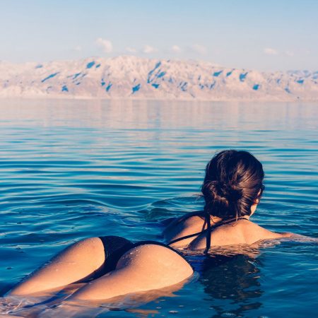 Person in black swimsuit floats on calm water