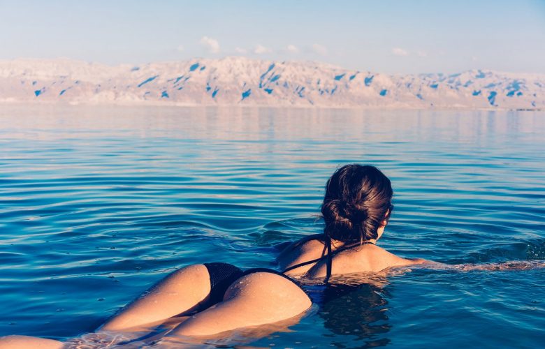 Person in black swimsuit floats on calm water