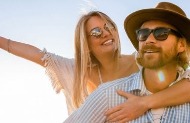 A joyful woman leans on a man outdoors