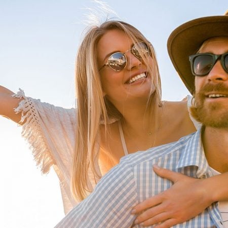 A joyful woman leans on a man outdoors