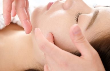 A person receives a facial massage in a calm spa setting