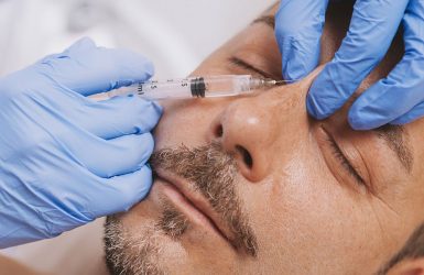 A professional injects a substance into a relaxed person's face during a non-surgical facelift.