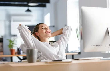 Woman in white shirt relaxes at desk