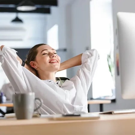 Woman in white shirt relaxes at desk