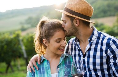 A couple in a vineyard: man kisses woman's forehead